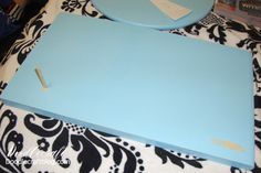 a blue cutting board sitting on top of a black and white table cloth with a piece of paper sticking out of it