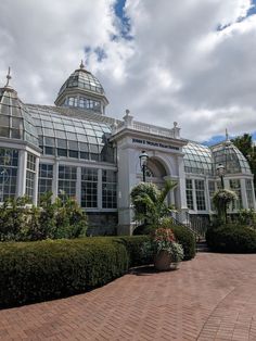 a large white building with many windows and plants