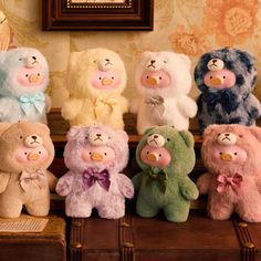 a group of stuffed animals sitting on top of a wooden table next to each other