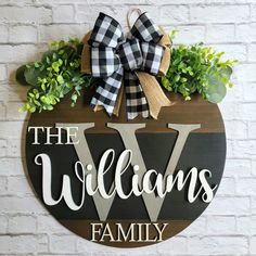 a wooden sign that says the williams family with a bow hanging on it's side