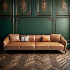 a brown leather couch sitting on top of a wooden floor next to a green wall