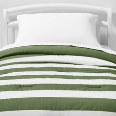 a bed with green and white striped sheets