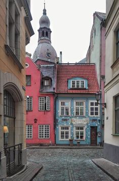 an alley way with several buildings and a clock tower in the backgrounge