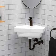 a white sink sitting under a bathroom mirror next to a shelf with towels on it