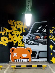 a parking garage with graffiti on the walls and an orange teddy bear painted on the wall