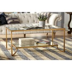 a living room with a couch, coffee table and books on the floor in front of it