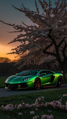 a green sports car parked in front of a blossoming tree