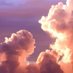 an airplane is flying through the clouds at sunset