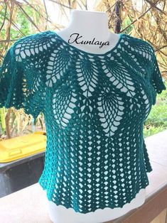 a green crocheted top on a mannequin