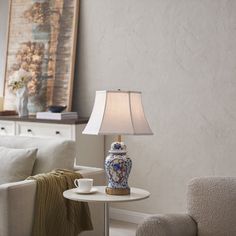 a living room scene with focus on the coffee table and vase sitting on the end table