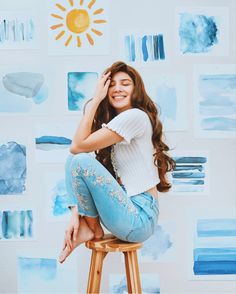 a woman sitting on top of a wooden stool