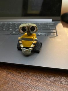 a small toy sitting on top of a laptop computer