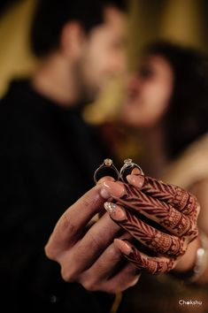 a bride and groom holding their wedding rings