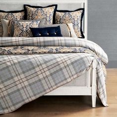 a bed with blue and white plaid comforter on it's side in a bedroom