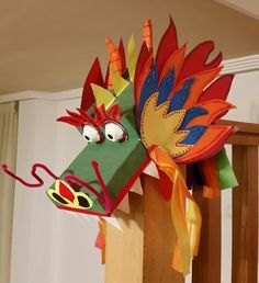 a dragon head made out of paper on top of a wooden post