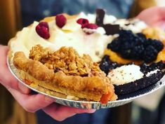 a person holding a pie with toppings on it