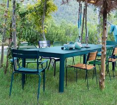 an outdoor dining table and chairs in the grass