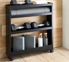 a shelf with some items on it in front of a wooden wall and wood floor