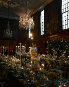 a bride and groom kissing in front of a chandelier at their wedding reception