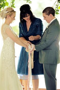 a bride and groom are getting married under a tree