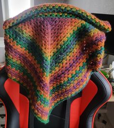 a colorful knitted hat sitting on top of a red chair