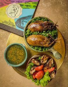 two bowls filled with different types of food on top of a table next to a cookbook