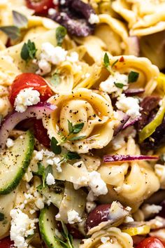 pasta salad with cucumbers, tomatoes, onions and feta cheese on top