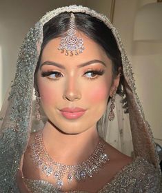 a woman wearing a bridal veil and jewelry