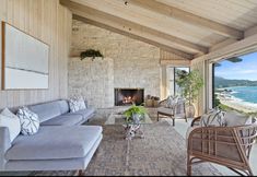 a living room filled with furniture and a fire place in front of a large window