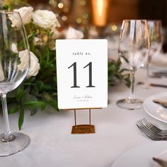 the table is set with wine glasses and place cards