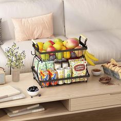 a coffee table topped with fruit and pastries on top of a wooden table next to a couch