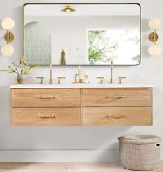 a bathroom vanity with two sinks and a large mirror above it, in front of a white wall