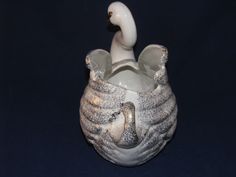 a white ceramic vase with a bird on it