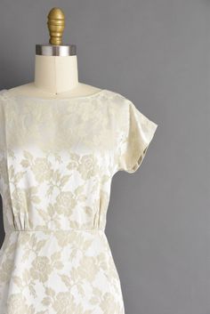 "Vintage 1950s dress in a wonderful ivory color with a lovely floral print throughout. This vintage dress features a flattering fitted bodice with bust darts, nipped waist, and a wonderful pencil skirt. There is a back metal zipper for closure. ✂------ M E A S U R E M E N T S ------- Best Fit: XS Bust: 32\" Waist: 24\" Hips: 34.5\" Shoulders: undefined Sleeves: 2\" Total Length: 36\" Material: silk brocade Condition: Excellent vintage condition. Ready to wear. ☆ Layaway is available for this ite Elegant Vintage Fashion Dresses With Floral Print, Fitted Beige Vintage Dress For Garden Party, Fitted Cream Dress In 1950s Style, Fitted Cream Vintage Dress With Floral Print, Cream Fitted Dress In 1950s Style, Cream Fitted 1950s Style Dress, 1950s Style Cream Dress, Cream 1950s Style Dresses, 1950s Style Fitted Cream Vintage Dress