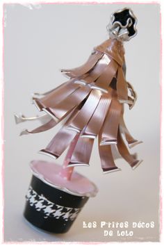 an ornament is hanging from a cup with ribbon around it and the top has been folded down