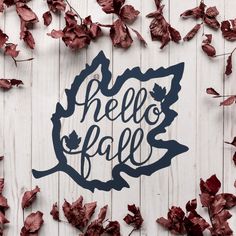 the word hello fall is surrounded by leaves on a white wooden background with red leaves