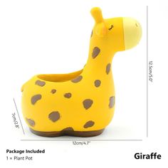 a giraffe shaped planter sitting on top of a white table next to a ruler