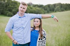 a man and woman posing for a photo in a field