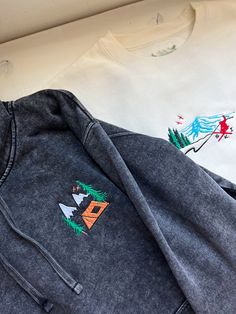 We sell primarily on our website where we offer  free shipping options. TwinRavenCo. See our website for a long-sleeve option as well.  This hoodie features a retro mountain camping vibe - perfect for any wintery adventure.  𓄿 Mineral Washed giving that perfect weathered look 𓄿 Unisex 𓄿 Split stitch double needle sewing on all seams 𓄿 Jersey lined hood 𓄿 1 x 1 ribbing at cuffs and waistband 𓄿 The embroidered design uses thread made from the highest quality, recycled materials 𓄿 Designed and embroidered in our studio in Canada * Check out our socials for discounts, new releases, and to see how we run our shop: TwinRavenCo Embroidery stabilizer is applied to the back of every embroidered item and is never to be removed. It is there to keep the stitches stable over time. This stabilize Outdoor Long Sleeve Cotton Hoodie, Cotton Hoodie For Outdoor, Cotton Long Sleeve Hoodie For Outdoor, Winter Hoodie With Embroidered Logo And Relaxed Fit, Cotton Hoodie With Graphic Print For Outdoor Activities, Cotton Hoodie With Graphic Print For Outdoor, Winter Long Sleeve Hoodie With Embroidered Logo, Graphic Print Cotton Hoodie For Outdoor Activities, Outdoor Long Sleeve Cotton Sweatshirt