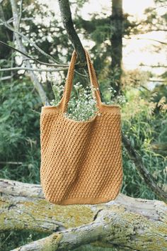 a straw bag hanging from a tree branch with text overlay reading summer harvest tote bag free crochet pattern