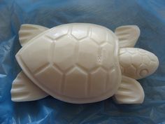 a plastic turtle toy laying on top of a blue sheet