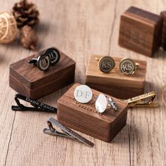 three wooden cufflinks with monogrammed initials are sitting on top of each other