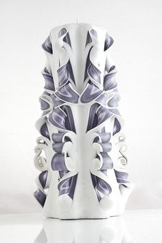 a white and purple vase sitting on top of a table