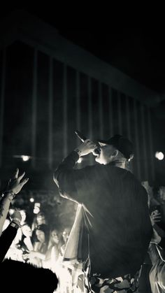 a man standing in front of a crowd holding his hands up