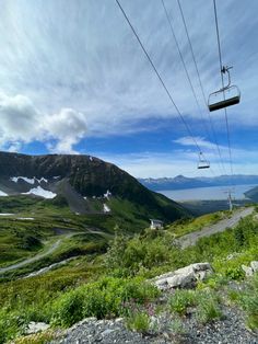 a ski lift going up the side of a mountain next to a body of water