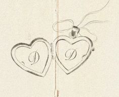 two heart shaped lockes with the letter d on them are hanging from a string