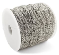 a spool of silver colored thread on white background with clipping for the top