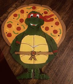 a paper plate shaped like a turtle holding a pizza