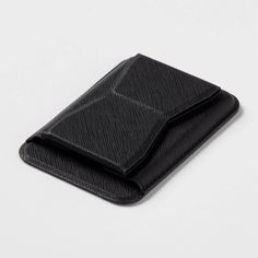 an empty black wallet sitting on top of a white surface with no one around it