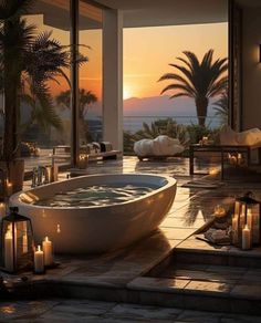 a large bath tub sitting on top of a tiled floor next to palm trees and candles